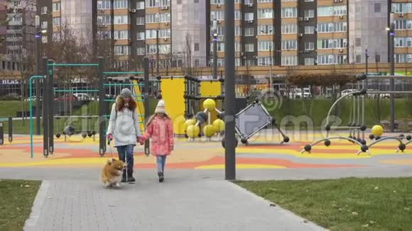 母女俩在公园的小巷里遛狗视频的预览图