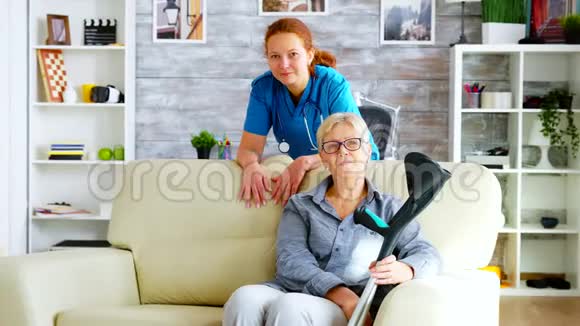 养老院的漂亮护士和坐在沙发上的老妇人视频的预览图