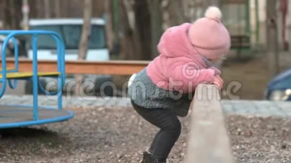 孤独的小女孩在儿童游乐场玩旋转木马视频的预览图