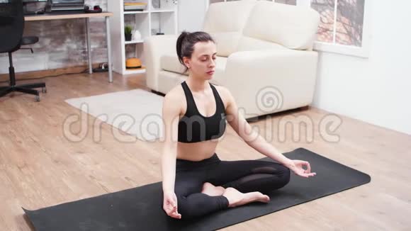 放松的年轻女子在瑜伽垫上做冥想视频的预览图