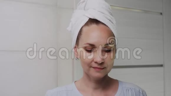 将成年妇女的头上铺上毛巾用水喷雾补充皮肤水分视频的预览图
