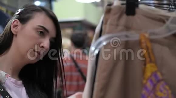 一名女子近距离观察跳蚤市场上的衣服视频的预览图