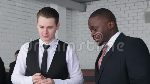 两个男人在工作中的对话穿西装的年轻商人在办公室里一起工作和交流公司法人视频的预览图