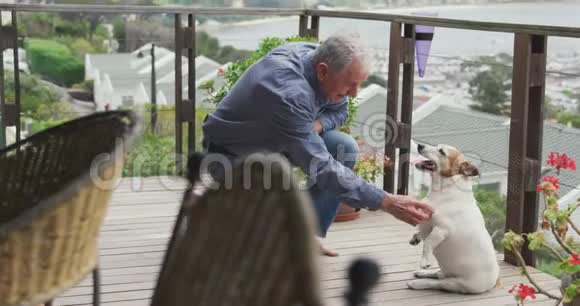 老人和他的狗在家的露台上视频的预览图