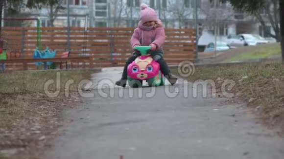 两岁的学步女孩骑着玩具车视频的预览图