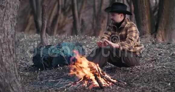 人在森林黄昏的火边休息视频的预览图