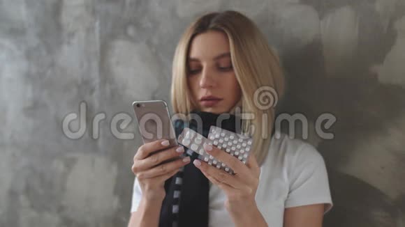 一个女人一只手拿着手机另一只手拿着一簇平板电脑站在灰色的背景下一个女孩视频的预览图