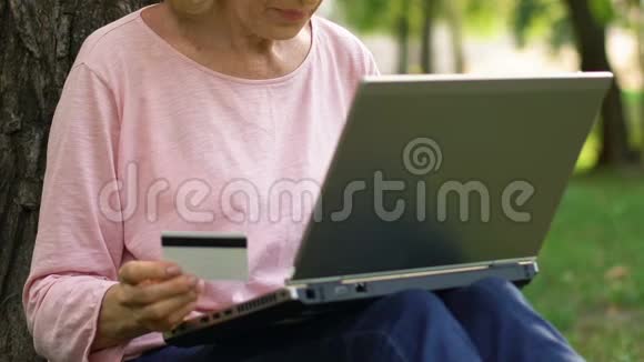 老妇人在网上购物用信用卡支付购买电子商务视频的预览图