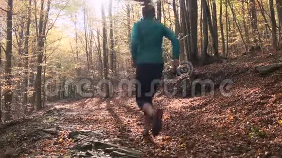 秋天的早晨运动的年轻女子在山上奔跑后景视频的预览图