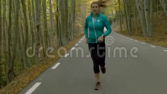 在美丽的大自然中奔跑在山路上的年轻女子视频的预览图