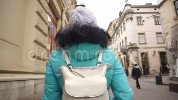 女游客沿着利沃夫市狭窄的老街散步美丽的建筑和地标背景视频的预览图