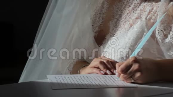 女孩手里拿着一支蓝色的钢笔写在笔记本上这个女孩穿着白色内衣一缕阳光视频的预览图