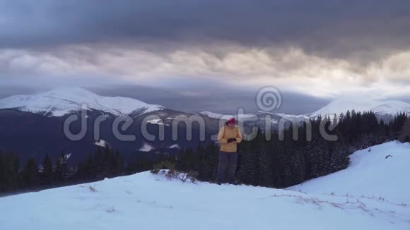 冬天一个旅行者在山上打电话视频的预览图