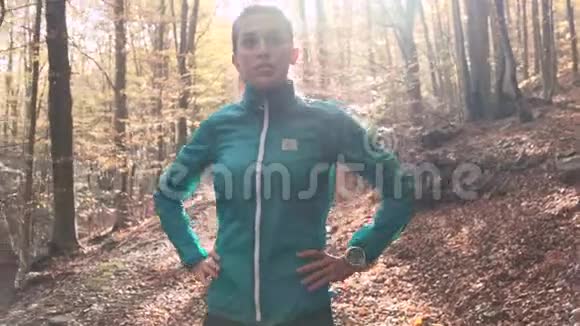 在秋天的早晨在山上跑步后一位运动的年轻女子四处张望一边放松视频的预览图