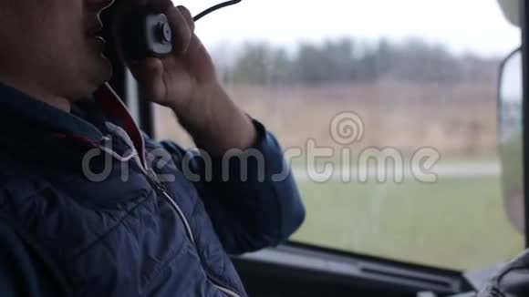 一名卡车司机在驾驶室对讲机上询问其他司机的交通情况传播的概念视频的预览图