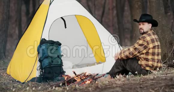 在森林里的帐篷和火堆旁休息的人视频的预览图