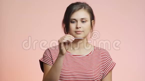 粉红工作室背景的年轻女性期待着看一次性医学妊娠检查但沮丧女孩视频的预览图