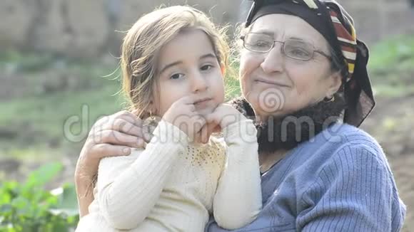 穆斯林祖母在花园聚会上亲吻她的小孙女视频的预览图