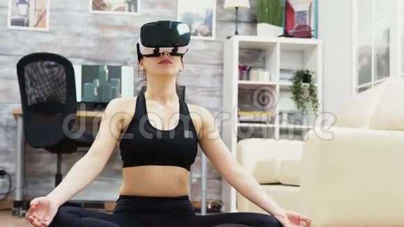 白种人女人用虚拟现实眼镜做瑜伽放松视频的预览图