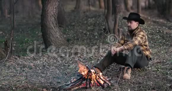 人在森林黄昏的火边休息视频的预览图