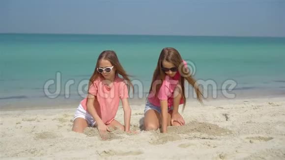 两个快乐的小女孩在热带海滩玩得很开心视频的预览图