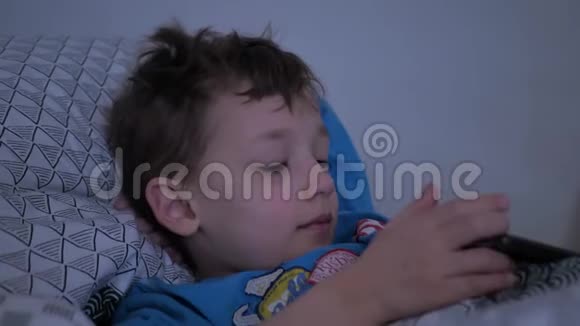 躺在床上玩智能手机的小孩视频的预览图