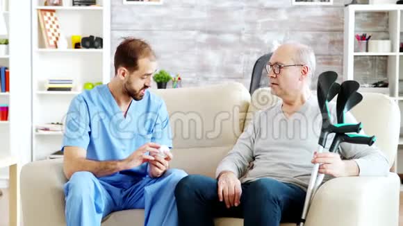 在养老院里一位男护士正在和一位拄着拐杖的老人谈话视频的预览图
