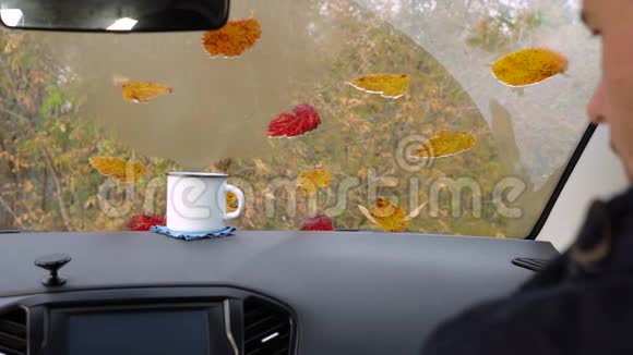 一个成年人坐在车里喝着杯子里的茶视频的预览图