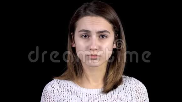 一个年轻的女人脸上流露出悲伤的情绪那个女人在黑色背景特写上很伤心视频的预览图