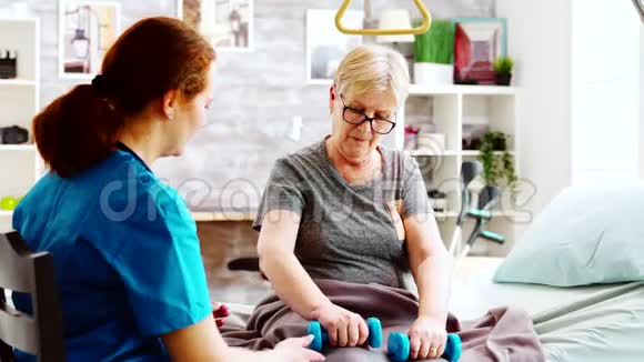 养老院的护士帮助一位老年妇女恢复肌肉力量视频的预览图