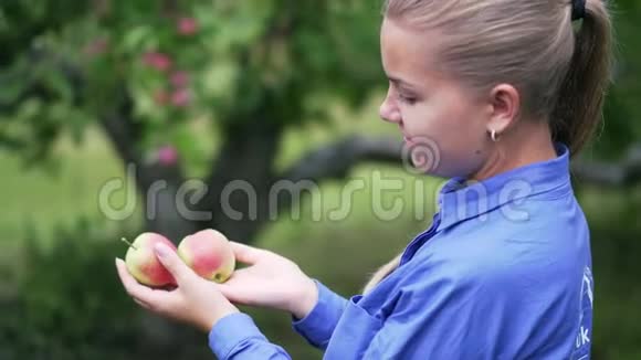 一个年轻的女孩手里拿着成熟的红苹果视频的预览图
