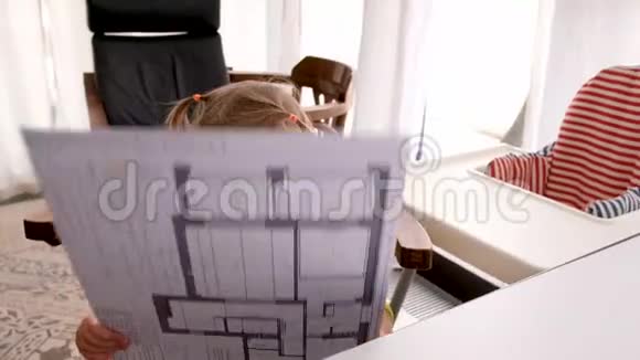 好奇的小男孩在家里的父母工作场所检查假装成人的草稿视频的预览图