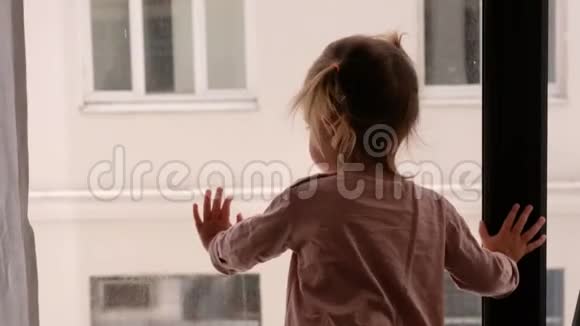 好奇的小女孩望着窗外视频的预览图
