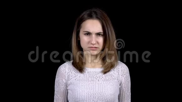 一个年轻女子脸上流露出厌恶的情绪女人在黑色背景下扭动着脸不让人讨厌视频的预览图