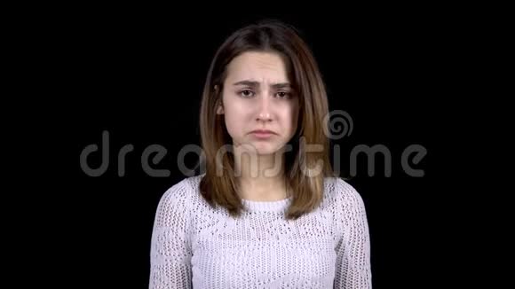 一个年轻的女人脸上流露出悲伤的情绪那个女人在黑色的背景下很伤心视频的预览图