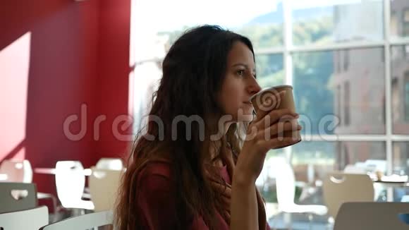 咖啡馆里的女人在背景全景窗户和群山中喝咖啡视频的预览图
