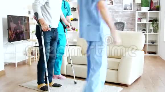 养老院护士团队帮助一位残疾老人坐在沙发上视频的预览图
