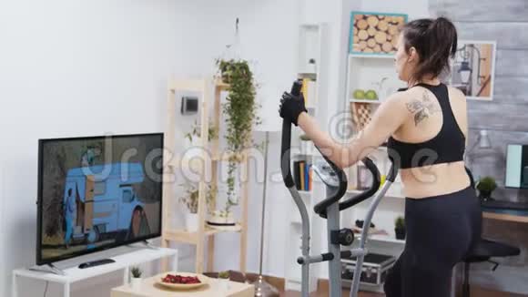 看电视锻炼身体的年轻女子视频的预览图