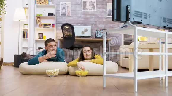 两个人坐在地板的枕头上看电视聊天视频的预览图