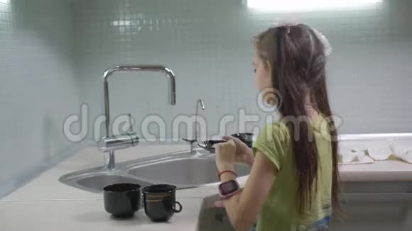 小女孩晚饭后在厨房洗杯子视频的预览图