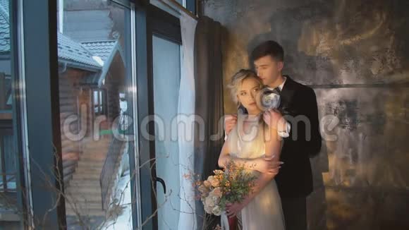 年轻夫妇站在窗户附近视频的预览图