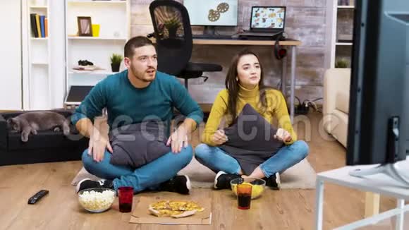 年轻夫妇坐在地板上欢呼雀跃视频的预览图