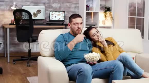 高加索夫妇在客厅里放松地看电视视频的预览图