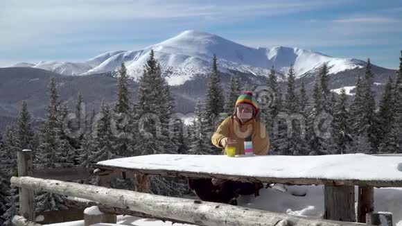 一个人坐着喝茶在冬天的景色背景下视频的预览图