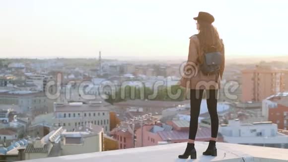站在屋顶上看城市风景的漂亮年轻女人视频的预览图