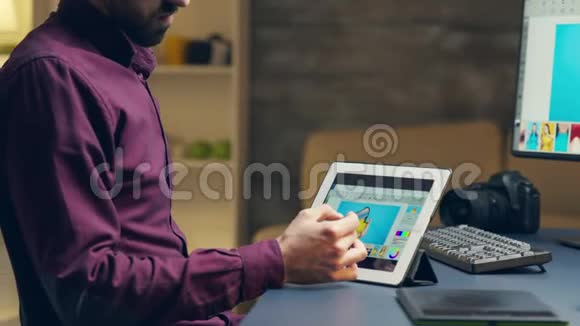年轻摄影师用钢笔在平板电脑上润色照片视频的预览图
