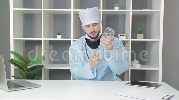 医生用药物观察罐子医生把一个大玻璃瓶里的药拨到注射器里准备工作视频的预览图