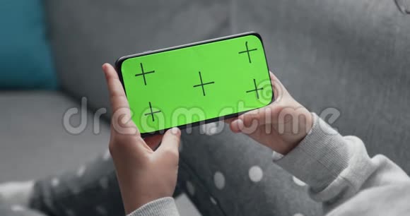 在女孩手里用绿色屏幕关闭智能手机视频的预览图