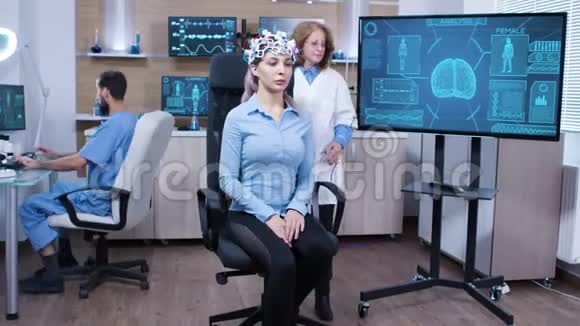 坐在椅子上戴脑电波扫描耳机的女人视频的预览图