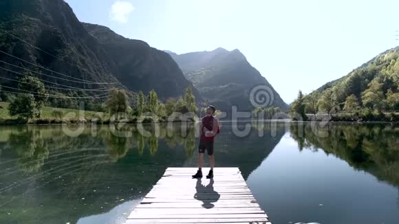 徒步旅行者带着背包看着湖中的风景视频的预览图